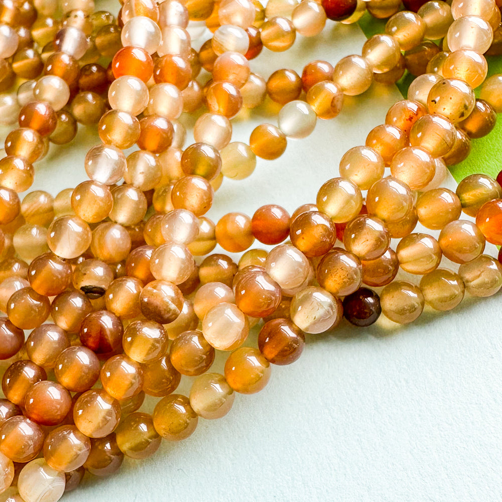 
                
                    Load image into Gallery viewer, 4mm Caramel Cay Round Agate Strand
                
            