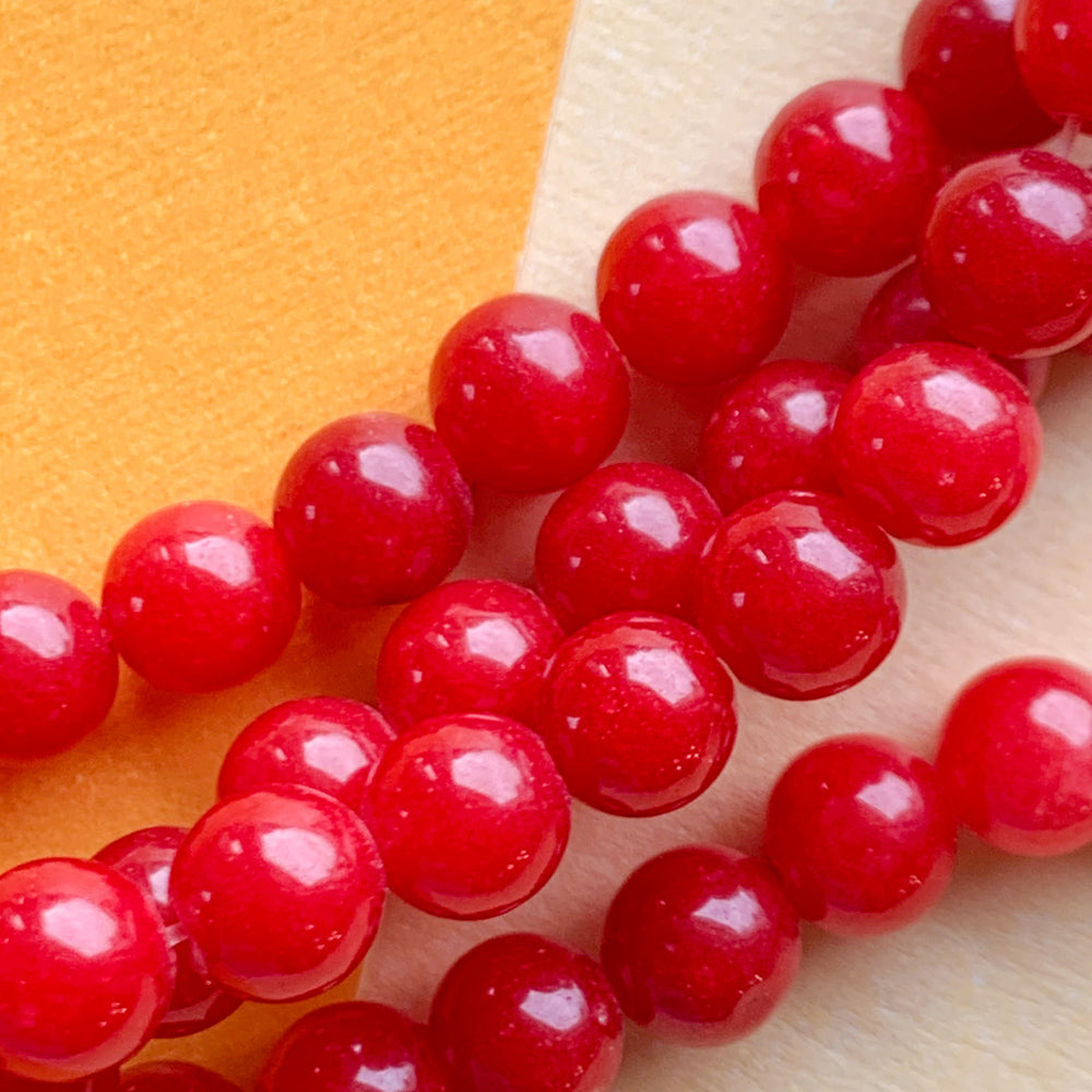
                
                    Load image into Gallery viewer, 6mm Smooth Red Dyed Jade Rounds Strand
                
            