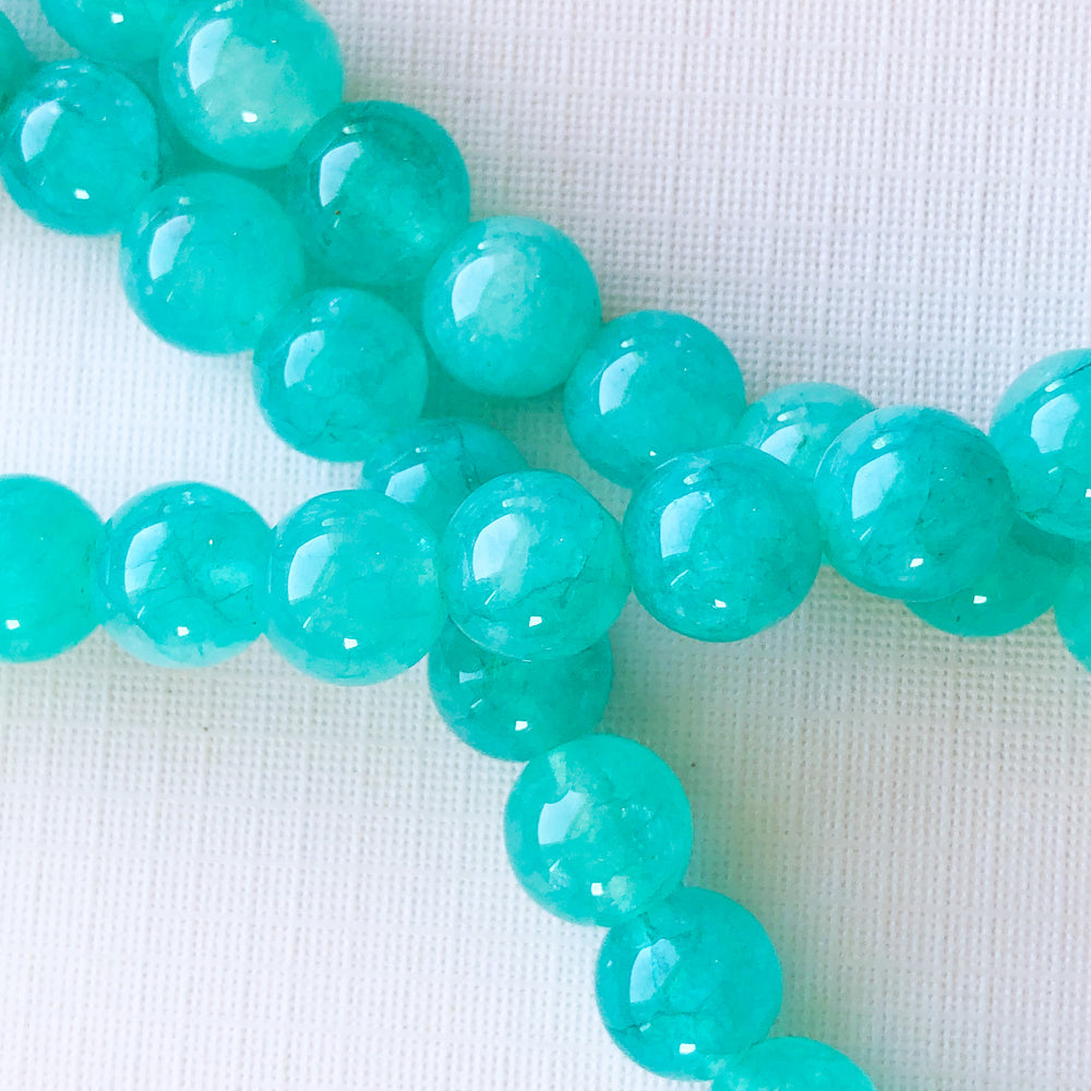 
                
                    Load image into Gallery viewer, 8mm Translucent Teal Dyed Jade Rounds Strand
                
            